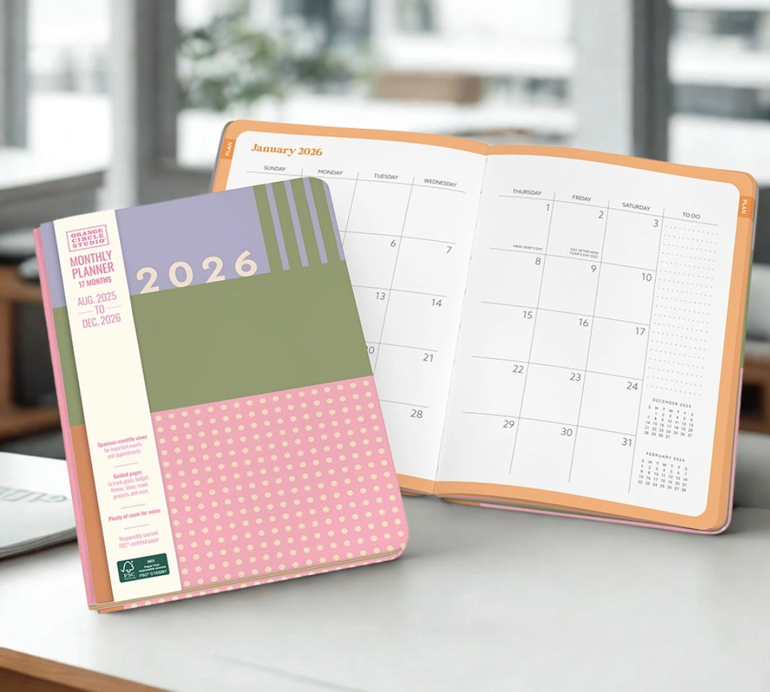 2026 planner with a colorful cover and an open planner on a desk.